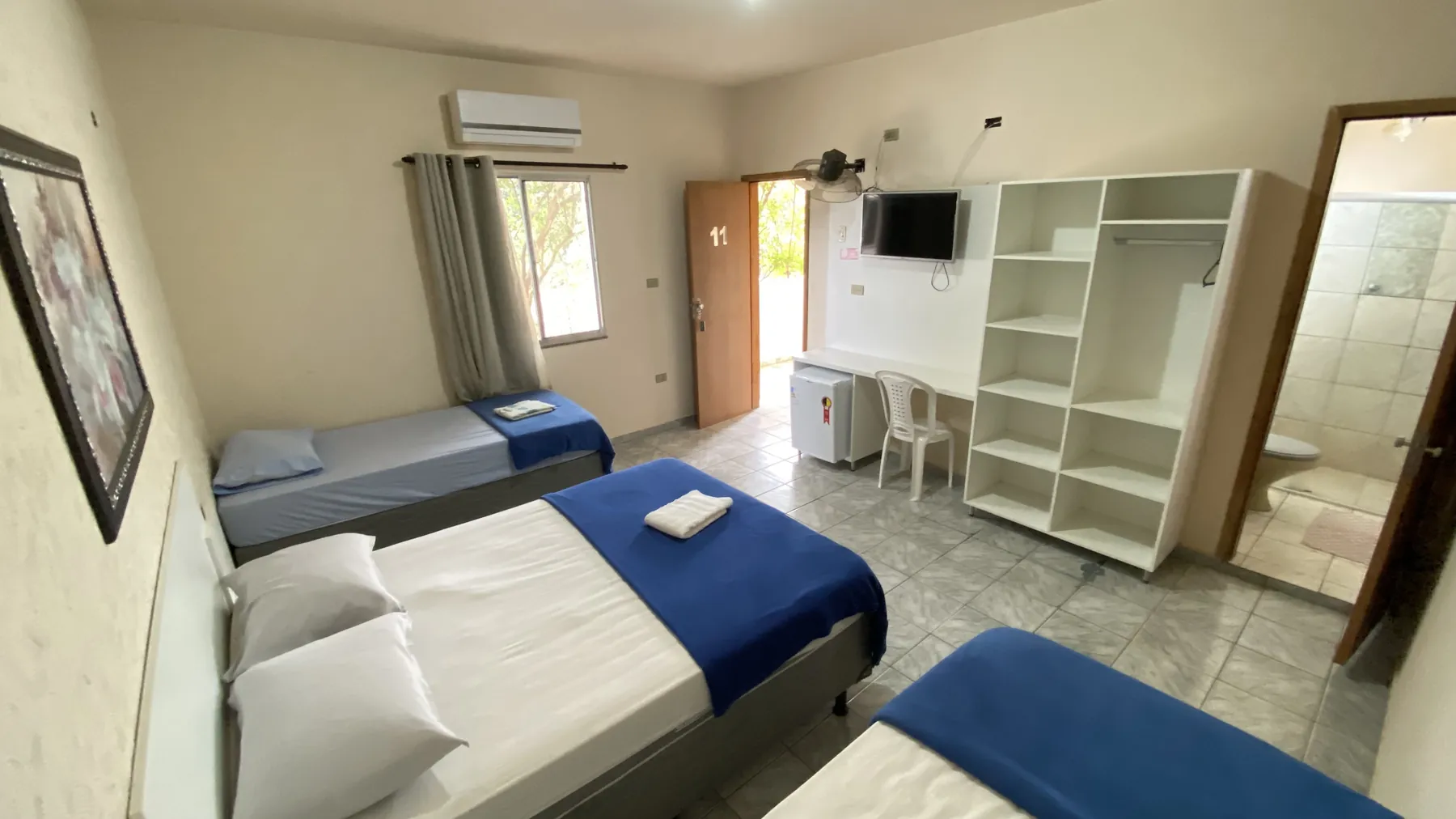 Quarto com três camas e guarda-roupa amplo